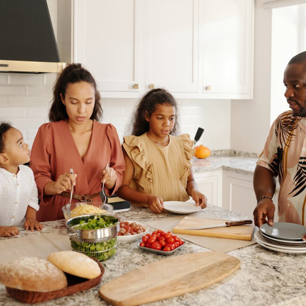 Family of four preparing food together in a kitchen